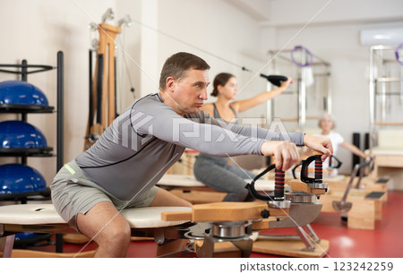 Adult man stretching her arms using pilates machine 123242259