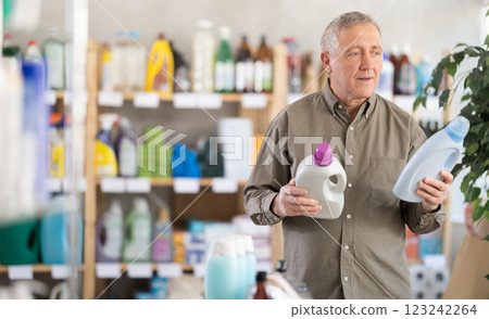 Elderly man choosing cleaning product in supermarket Elderly man choosing cleaning product in supermarket 123242264