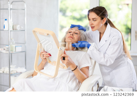 Elderly patient looking in mirror at clinic. Elderly patient looking in mirror at clinic. 123242369