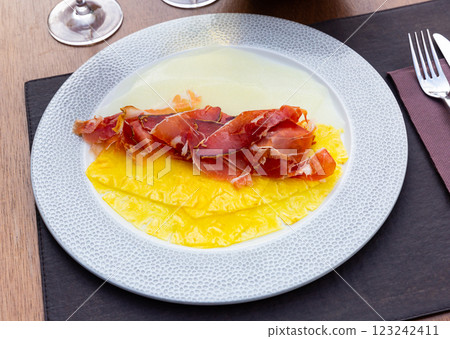 Delicious serving of pineapple and melon carpaccio with thinly sliced prosciutto Delicious serving of pineapple and melon carpaccio with thinly sliced prosciutto 123242411
