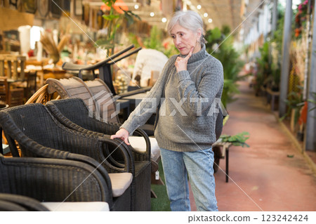 Aged woman choosing chair in furniture shop 123242424