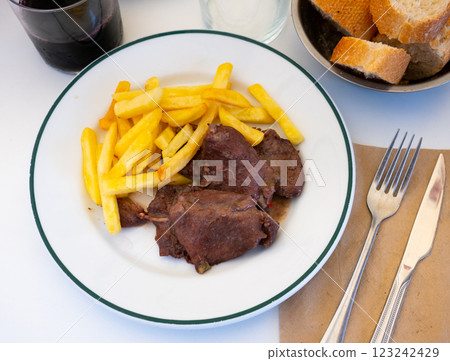 Secreto de cerdo - fried pork in red, served with french fries Secreto de cerdo - fried pork in red, served with french fries 123242429