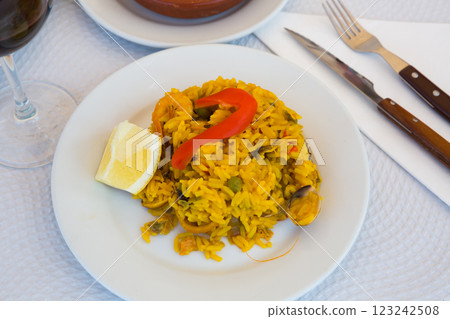 Paella with shrimp, pepper, vegetables and lemon on platter Paella with shrimp, pepper, vegetables and lemon on platter 123242508