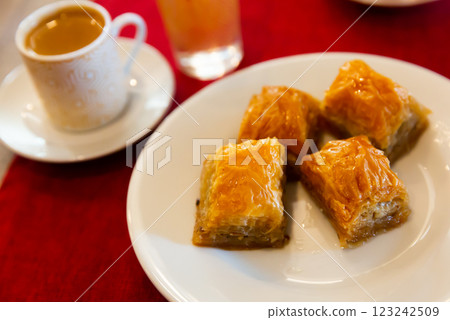 Traditional Turkish dessert - baklava on a plate and cup of coffee Traditional Turkish dessert - baklava on a plate and cup of coffee 123242509