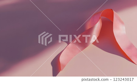 Elegant pink ribbon on a minimalist backdrop symbolizing the fight against breast cancer during Awareness Month. Awareness concept 123243017