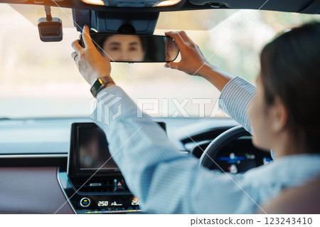 Business woman driver adjusting rear view mirror a car. Journey, trip and safety Transportation concepts Business woman driver adjusting rear view mirror a car. Journey, trip and safety Transportation concepts 123243410