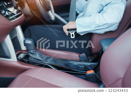 Business woman driver hand fastening seat belt during sitting inside a car and driving in the road. safety, trip, journey and transport concept Business woman driver hand fastening seat belt during sitting inside a car and driving in the road. safety, trip, journey and transport concept 123243433