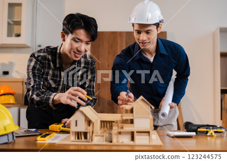 team discussing data working and tablet, laptop with on architectural project at construction site at desk in office. team discussing data working and tablet, laptop with on architectural project at construction site at desk in office. 123244575