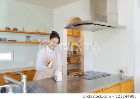 A woman who is making coffee A woman who is making coffee 123244993