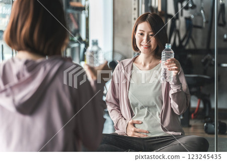 Pre-mom and pregnant women exercising, stretching, and doing maternity training at the gym during pregnancy Pre-mom and pregnant women exercising, stretching, and doing maternity training at the gym during pregnancy 123245435