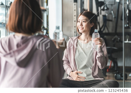 Pre-mom and pregnant women exercising, stretching, and doing maternity training at the gym during pregnancy Pre-mom and pregnant women exercising, stretching, and doing maternity training at the gym during pregnancy 123245436
