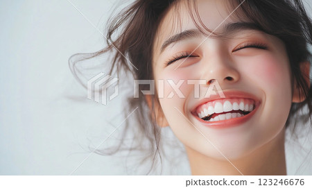 Radiant Joy: Close-up of a smiling woman with closed eyes, showcasing happiness, healthy teeth, and a clean, bright complexion. 123246676