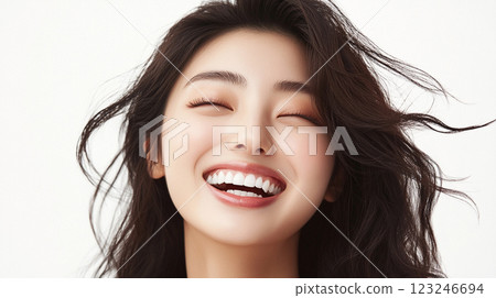 Radiant woman with closed eyes and a bright smile. She emanates pure happiness, her beautiful white teeth are the focal point of the image. 123246694