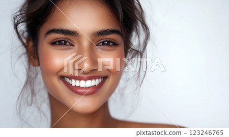 Radiant Smile: Close-up portrait of a beautiful woman with flawless skin and a beaming, confident expression against a plain background. Radiant Smile: Close-up portrait of a beautiful woman with flawless skin and a beaming, confident expression against a plain background. 123246765