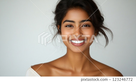 Radiant Portrait: Woman's captivating smile illuminates a clean studio shot, highlighting her flawless complexion and beautiful features. 123246772