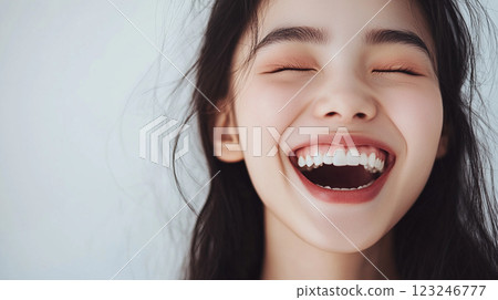Radiant joy captured! A smiling woman with closed eyes exudes pure happiness, showcasing perfect teeth and a carefree spirit. 123246777