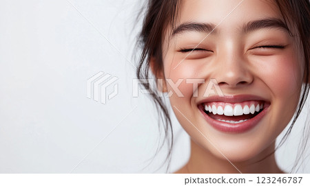 Radiant Smile: A close-up of a young woman's joyful expression with closed eyes and a beaming white smile against a bright, clean background. Radiant Smile: A close-up of a young woman's joyful expression with closed eyes and a beaming white smile against a bright, clean background. 123246787