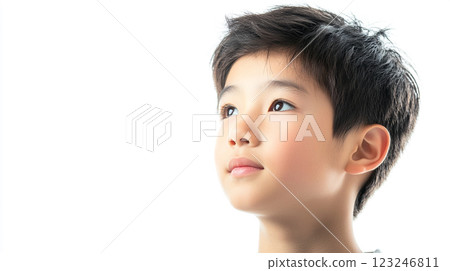 A young boy gazes thoughtfully upward against a bright white background, capturing a moment of childlike wonder and introspection. A young boy gazes thoughtfully upward against a bright white background, capturing a moment of childlike wonder and introspection. 123246811