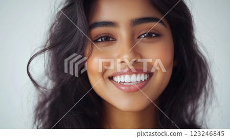 Radiant smile lights up the face. Her perfect teeth and soft waves beautifully accentuate her beauty against a clean white background. 123246845