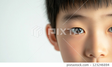 Child portrait featuring the eye and eyebrow in sharp focus, soft light highlights skin details against a blurred background. 123246894