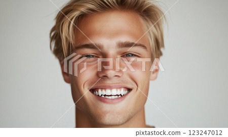 Close up of a smiling blond man. Clean shaven and teeth bared. Handsome, light skin man with an engaging toothy smile looking directly at the viewer. Close up of a smiling blond man. Clean shaven and teeth bared. Handsome, light skin man with an engaging toothy smile looking directly at the viewer. 123247012