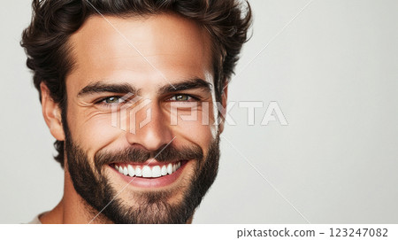 Smiling man portrait: A close-up of a handsome man with a beard, showcasing his bright white teeth and warm, inviting smile. Smiling man portrait: A close-up of a handsome man with a beard, showcasing his bright white teeth and warm, inviting smile. 123247082