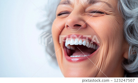 Close-up of a mature woman with closed eyes and mouth open wide, her face beaming with joy, captured with brilliant white teeth. Close-up of a mature woman with closed eyes and mouth open wide, her face beaming with joy, captured with brilliant white teeth. 123247507