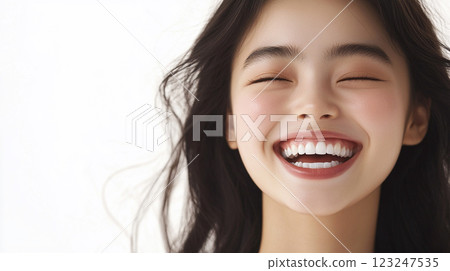Radiant joy on a youthful face, eyes closed, a genuine smile, and dark hair cascading against a crisp, white background. Pure happiness. Radiant joy on a youthful face, eyes closed, a genuine smile, and dark hair cascading against a crisp, white background. Pure happiness. 123247535