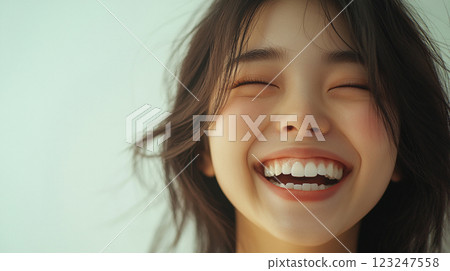 Close-up of a joyful woman with closed eyes, flashing a radiant smile. The image emphasizes happiness and well-being with light and soft tones. Close-up of a joyful woman with closed eyes, flashing a radiant smile. The image emphasizes happiness and well-being with light and soft tones. 123247558