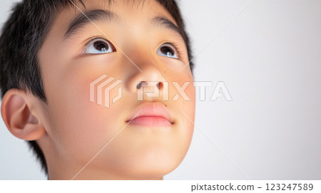 Boy with fair skin, short dark hair, looking up into space. He is thoughtful and curious as he ponders something in his mind. 123247589