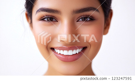 Close-up portrait of a young woman with radiant skin, long lashes, and a bright, healthy smile, set against a clean, soft background. Close-up portrait of a young woman with radiant skin, long lashes, and a bright, healthy smile, set against a clean, soft background. 123247591