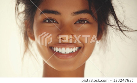 Radiant woman with a captivating smile, her eyes sparkling with joy. A portrait of natural beauty and confidence. Clean and healthy teeth. 123247655