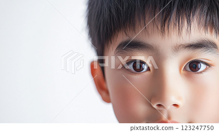 Close-up view reveals a young boy's face with soft lighting, capturing the innocence and clarity in his dark brown eyes and features. Close-up view reveals a young boy's face with soft lighting, capturing the innocence and clarity in his dark brown eyes and features. 123247750