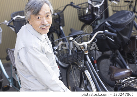 穿著工作服、騎腳踏車的男人 123247865