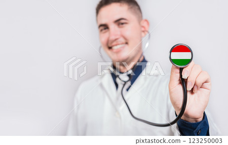Young Doctor Showing Stethoscope With Hungary Flag. Hungary National Healthcare Concept Young Doctor Showing Stethoscope With Hungary Flag. Hungary National Healthcare Concept 123250003