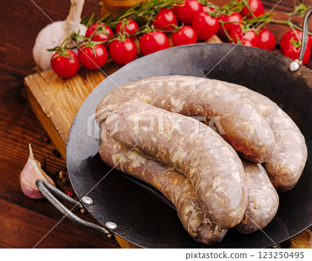 Fresh sausages ready for cooking in a rustic kitchen setting Fresh sausages ready for cooking in a rustic kitchen setting 123250495