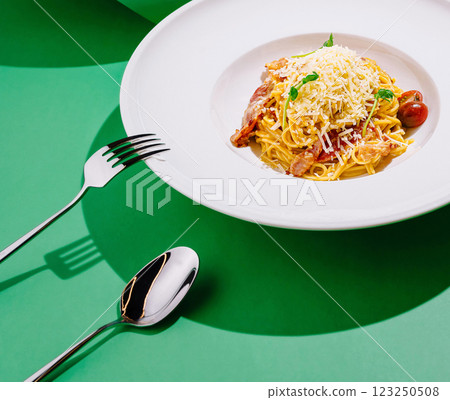 Spaghetti served with cheese and cherry tomatoes on green background Spaghetti served with cheese and cherry tomatoes on green background 123250508