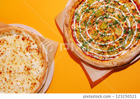 Delicious pizzas with unique toppings on vibrant background 123250521
