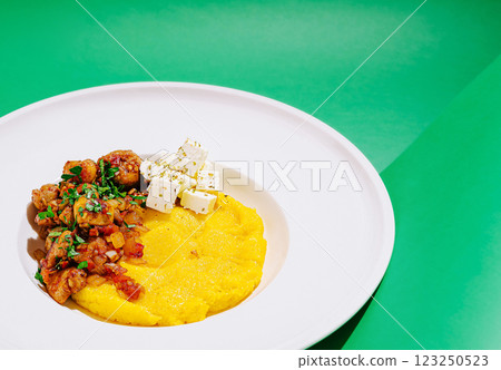 Polenta with veggies and cheese on a green surface Polenta with veggies and cheese on a green surface 123250523