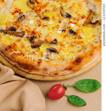 Freshly baked chicken and mushroom pizza on wooden board Freshly baked chicken and mushroom pizza on wooden board 123250563