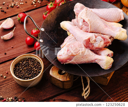 Fresh chicken drumsticks prepared for cooking in a rustic kitchen 123250628