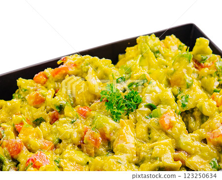 Fresh guacamole with vegetables served in a black bowl 123250634
