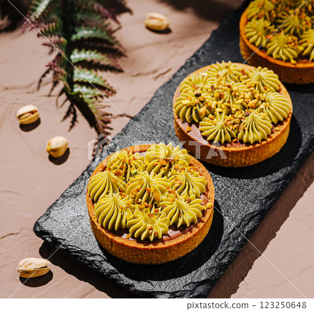 Delicious pistachio tart displayed on a slate serving board 123250648