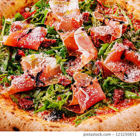 Perfectly crafted pizza topped with arugula and prosciutto 123250651