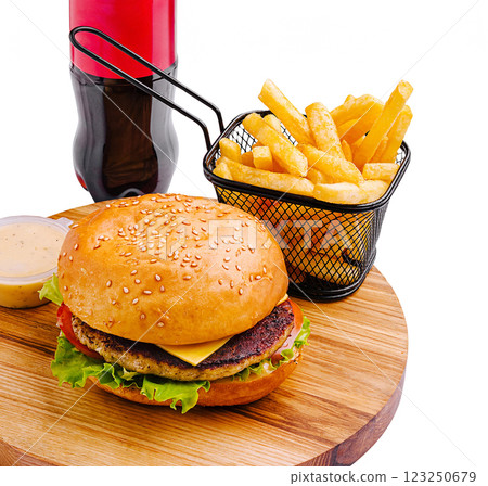 Tasty burger and fries served with soft drink on wooden platter 123250679