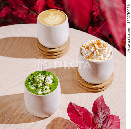 Colorful coffee drinks on a wooden table with autumn leaves 123250686