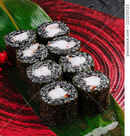 Sushi rolls served on a vibrant plate with fresh ingredients 123250723