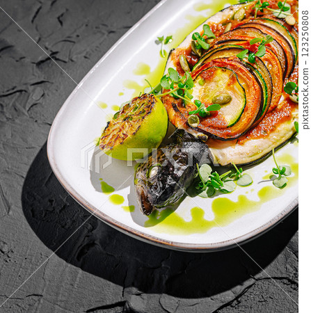 Gourmet dish featuring grilled fish and vibrant vegetable medley 123250808