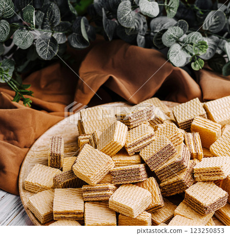 Sweet layered wafers arranged on a wooden platter at home 123250853