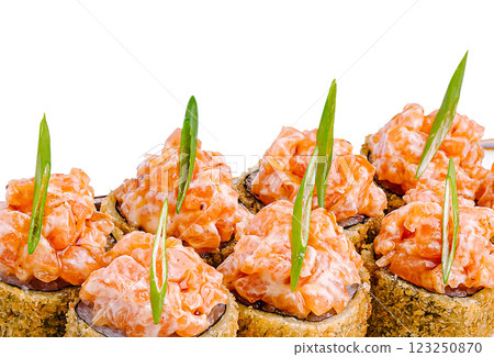 Delicious sushi rolls topped with spicy salmon and garnished Delicious sushi rolls topped with spicy salmon and garnished 123250870